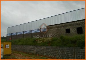 Veneziana Policarbonato instalada em fachada industrial, proporcionando ventilação natural e iluminação suave com alta resistência e leveza estrutural