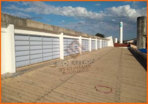 Veneziana Industrial Futuro Econômico, A imagem apresenta um lanternim elegante e moderno da empresa Solution instalado no teto de uma edificação, destacando-se contra o céu claro. Essa estrutura permite a entrada abundante de luz natural, iluminando o interior do espaço de forma eficiente e sustentável. Além disso, o design do lanternim facilita a ventilação natural, promovendo a circulação de ar fresco e a remoção do ar quente acumulado, garantindo assim um ambiente de trabalho mais confortável e saudável.