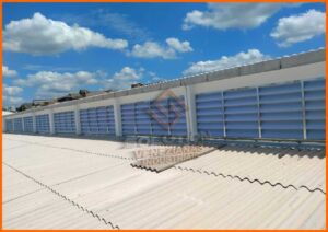Lanternins da Solution Lanternins da Solution A imagem apresenta os lanternins da Solution, instalados no telhado de uma edificação industrial ou comercial. Estes dispositivos, com design moderno e funcional, permitem a entrada de luz natural e facilitam a ventilação do ambiente. Eles são construídos com materiais resistentes, adaptando-se harmoniosamente à estrutura do edifício. A luz do dia que penetra através dos lanternins ilumina o interior, criando um espaço mais acolhedor e energeticamente eficiente. A cena captura a eficácia dos lanternins da Solution em proporcionar uma solução sustentável e econômica para iluminação e ventilação, melhorando significativamente a qualidade do ambiente de trabalho.