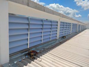 Veneziana Industrial na Ventilação Cruzada aplicada em galpão industrial, promovendo renovação de ar natural, eficiência térmica e maior conforto interno com baixo custo.