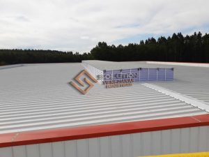 Lanternim Iluminação Superior com iluminação natural acentuada em cobertura industrial, promovendo claridade contínua e economia de energia elétrica