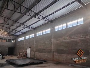 Venezianas de policarbonato translúcidas instaladas em fachada industrial, proporcionando ventilação e iluminação natural ao ambiente.