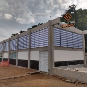 Detalhe das venezianas industriais instaladas em galpão moderno para ventilação eficiente.