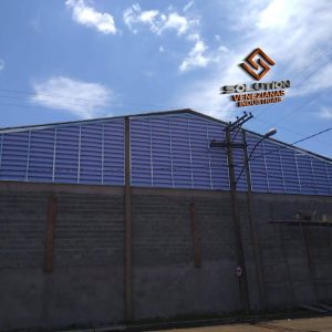 Veneziana Industrial Solução PVC instalada em galpão industrial, oferecendo ventilação permanente, resistência à umidade e longa durabilidade com baixa manutenção